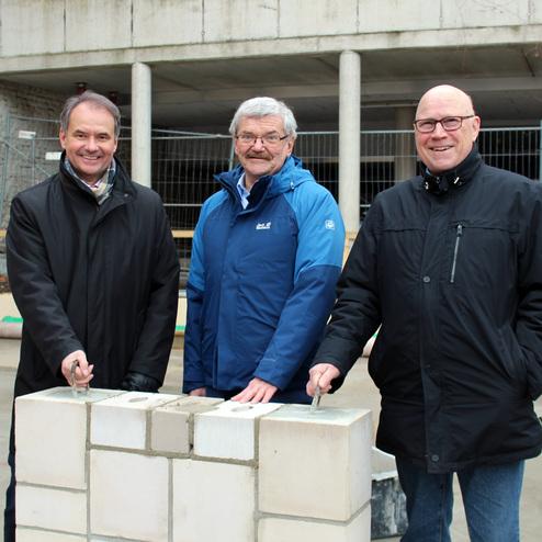 Hier siehst du zwei Männer zusammen mit unserem Präsidenten Otto Schlieckmann bei der Grundsteinlegung.