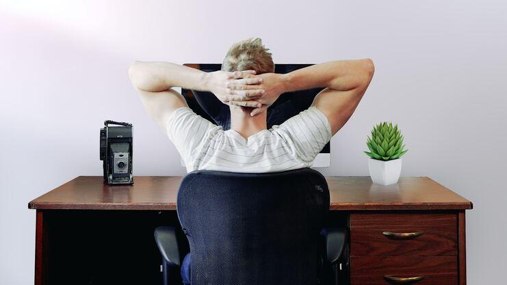 Hier siehst du einen Mann, der an seinem Arbeitsplatz sitzt.