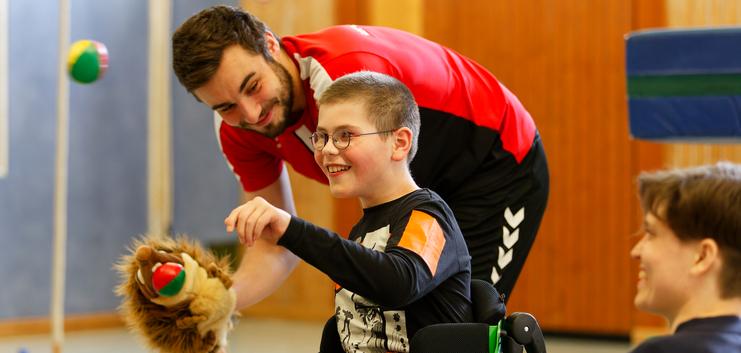 Hier siehst du ein Kind zusammen mit einem Trainer bei den Rollikids.