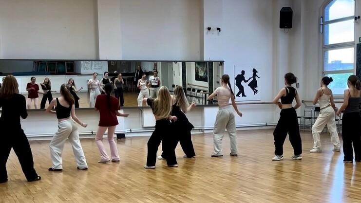 Hier siehst du Mädchen, die vor einem Spiegel tanzen.