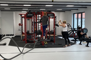 Hier siehst du unsern Synrgy Turm, an dem drei Frauen trainieren.