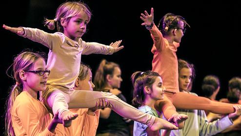 Hier siehst du die Akrobatinnen, die zu zweit ein Kind hochheben.