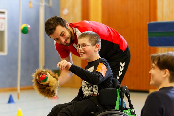 Hier siehst du ein Kind zusammen mit einem Trainer bei den Rollikids.
