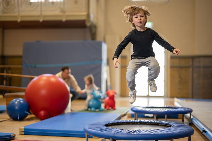 Hier siehst du ein Kind, dass auf einem Trampolin springt. In unser MTV Halle beim Kinderturnen.
