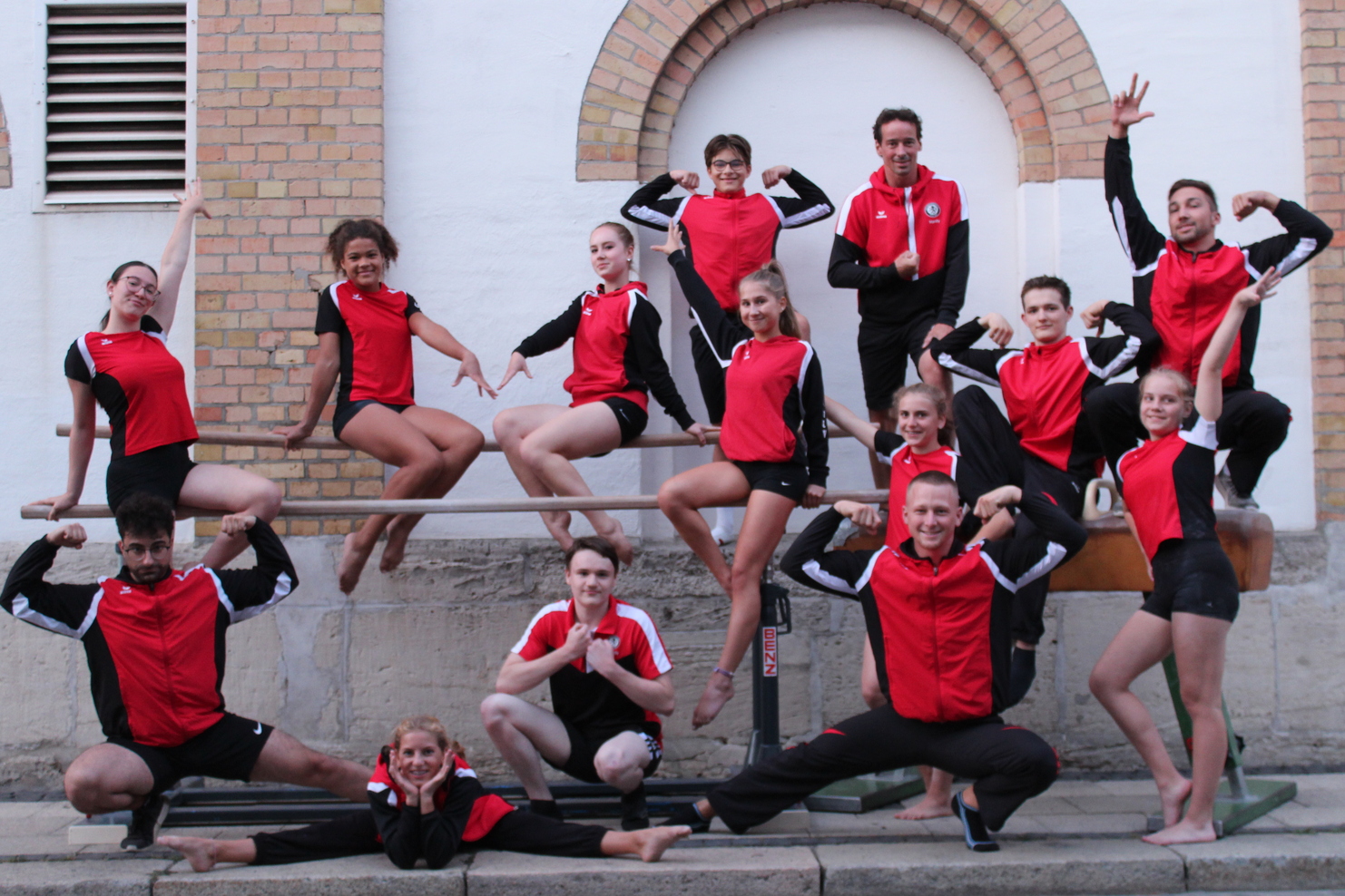 Hier siehst du unsere Turner und Turnerinnen die auf einem Barren posieren.